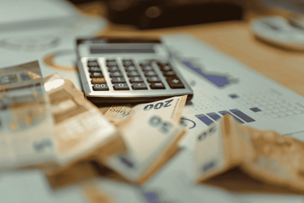 close up shot of calculator and dollar bills on table