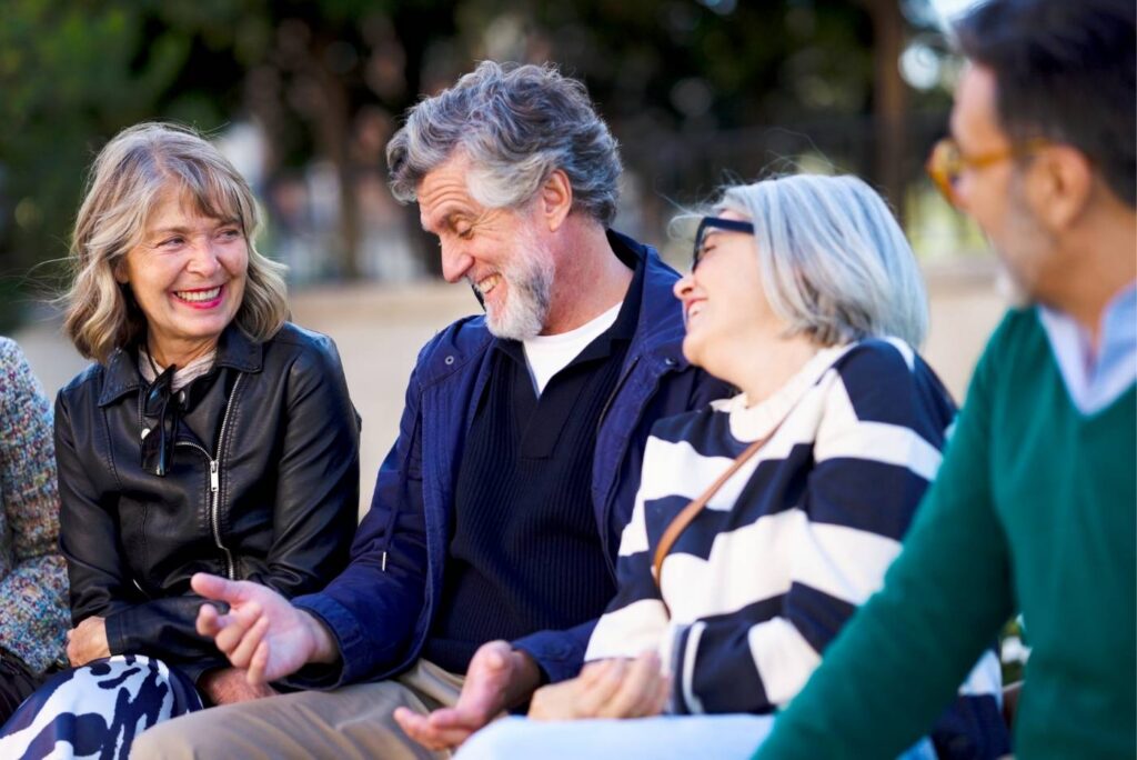 Seniors group laughing together socializing outdoors